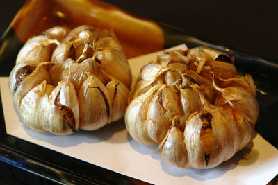 Close-up of deep fried garlic served in plate on paper