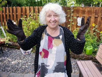 Portrait of a beautiful gray-haired seventy-year-old woman in work gloves. work in the backyard. 