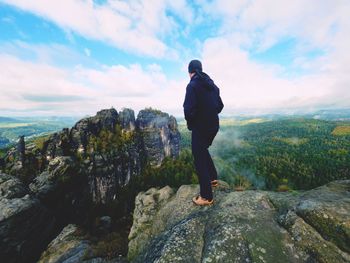 Rear view of man looking at mountain against sky