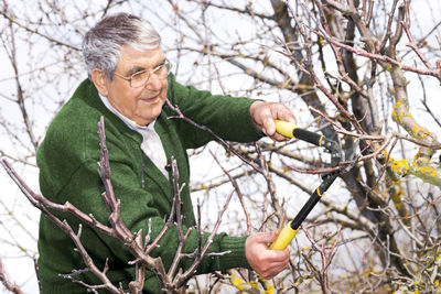 Young man holding fruit on tree