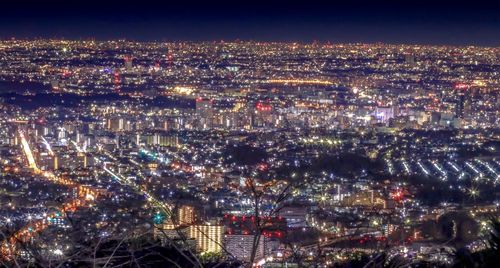 High angle view of illuminated cityscape against sky at night