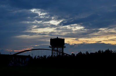 Low angle view of water tower against sky during sunset