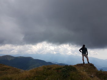 Woman standing on mountain against sky