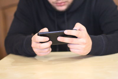 Midsection of man using mobile phone