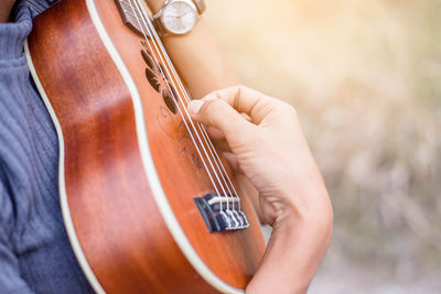 Midsection of person playing guitar