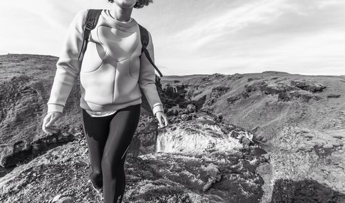 Midsection of young woman walking on mountains