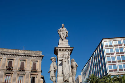 Low angle view of statue against blue sky