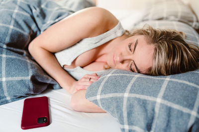 High angle view of woman lying on bed at home