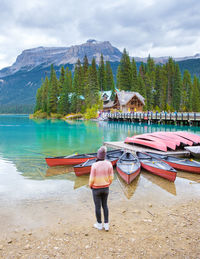 Rear view of woman standing by lake