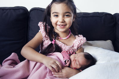 Portrait of girl holding baby sister