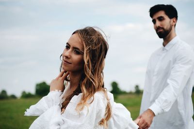 Close-up of couple with holding hands against sky