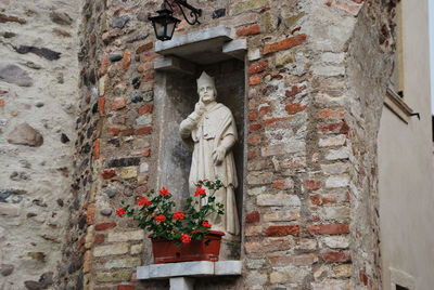 Low angle view of statue against building wall