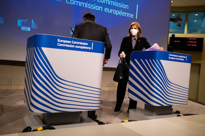 Rear view of people standing on sign board