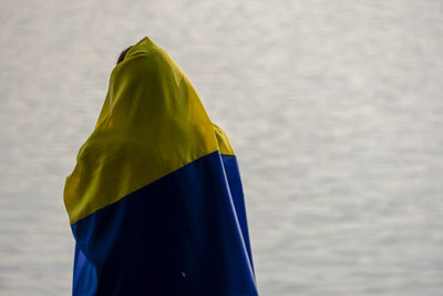 Girl wearing the ukraine flag protest war violence against the backdrop of a river.