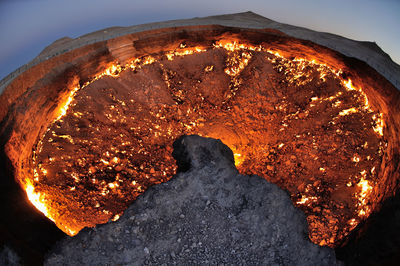 Close-up of illuminated lighting equipment on rock against sky