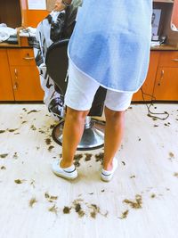 Rear view of hairdresser working in hair salon