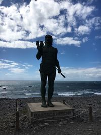 Rear view of man photographing sea against sky