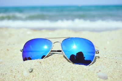 Close-up of sunglasses on beach