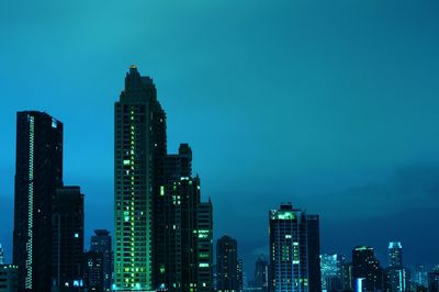 Illuminated buildings in city against sky at night