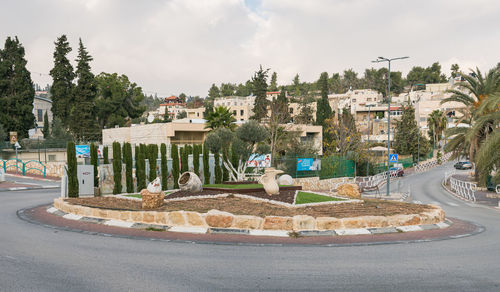 Panoramic shot of buildings by road against sky in city