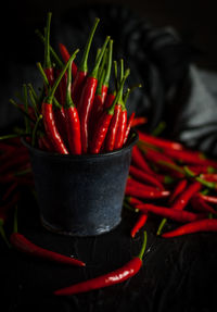 Close-up of red chili peppers in container on table