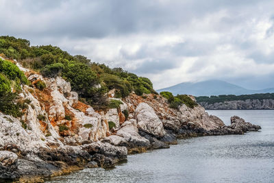 Rock formations by sea against sky