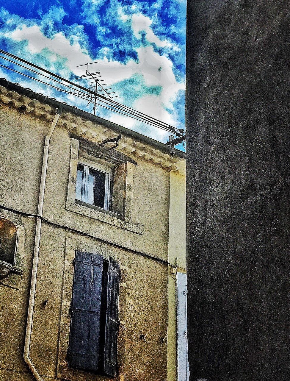 architecture, built structure, building exterior, window, sky, cloud - sky, wall - building feature, low angle view, building, blue, day, no people, outdoors, street, cloud, house, residential structure, residential building, wall, sunlight