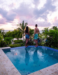 Rear view of young woman standing in swimming pool