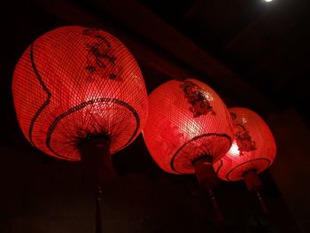 Low angle view of illuminated lanterns hanging in darkroom