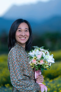 Portrait of a smiling woman standing against blue sea