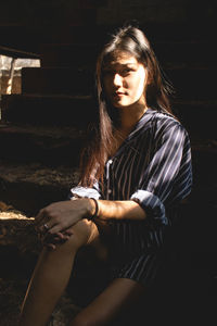 Young woman sitting in abandoned building