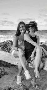 Portrait of a smiling young woman sitting on beach