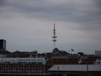 Buildings in city against cloudy sky