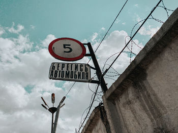 Low angle view of road sign against sky