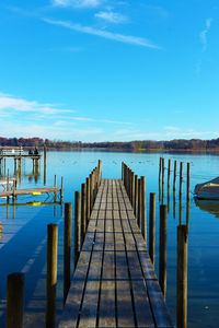 Pier over lake against blue sky