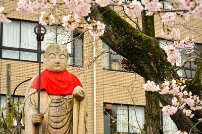 Low angle view of statue against building and trees