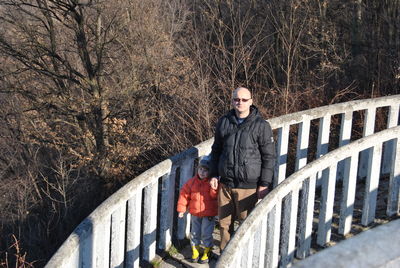 High angle view portrait of father and son walking on footbridge
