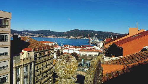 Panoramic view of cityscape by sea against clear blue sky