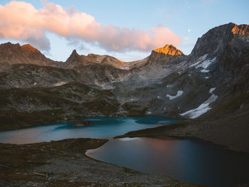 Scenic view of lake by snowcapped mountains against sky
