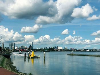 Scenic view of river by buildings against sky