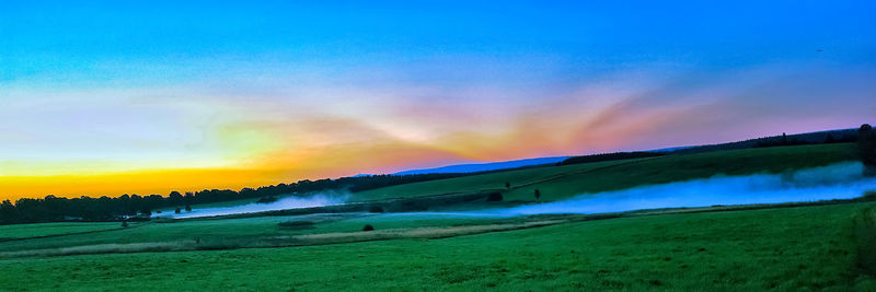 Scenic view of field against sky during sunset