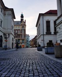 People walking on street amidst buildings in city