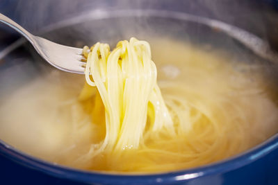 Spaghetti is cooked in boiling water in a saucepan