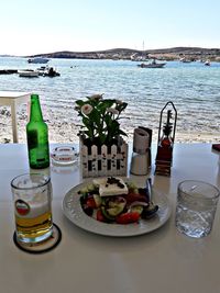 Food on table by sea against sky