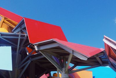 Low angle view of multi colored buildings against clear blue sky