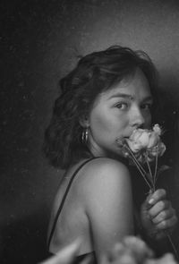 Portrait of young woman holding rose