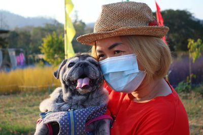 Portrait of woman with dog wearing hat