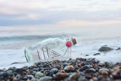 Close-up of bottle on shore