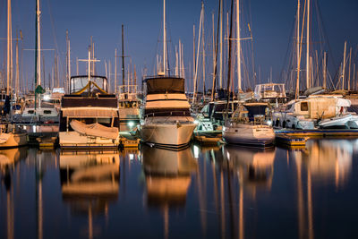 Sailboats moored in harbor