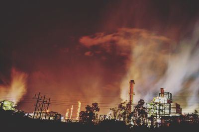 Low angle view of smoke emitting from factory against sky